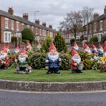 Garden gnomes standing on a grassy English roundabout island